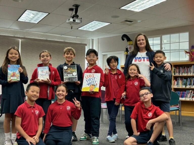 Teacher leading a small group of students in a hands-on enrichment activity in a classroom setting.