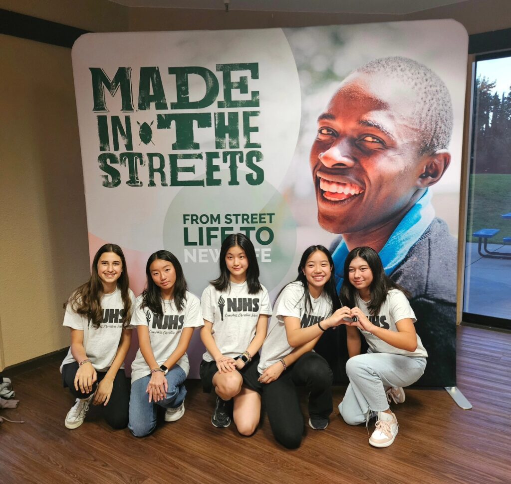 Community members and students collaborating outdoors, engaging in mentorship and street-level initiatives.