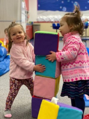 Teachers engaging with young students in small group learning, highlighting low child-to-teacher ratios