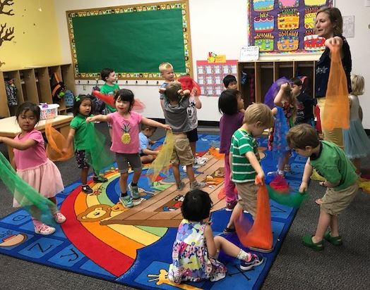 Teacher interacting with a small group of young students in a classroom