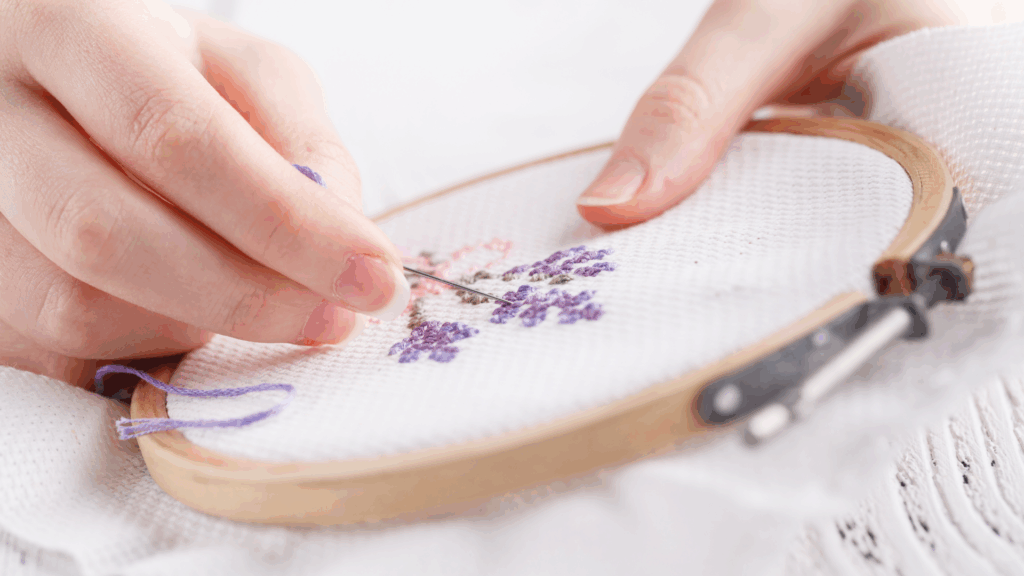 Students practicing embroidery stitching techniques in a classroom setting, creating needlework and friendship bracelet designs.